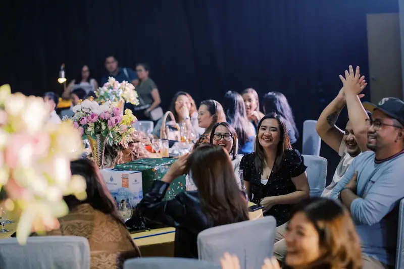 Teammates cheering at their table during an evening program