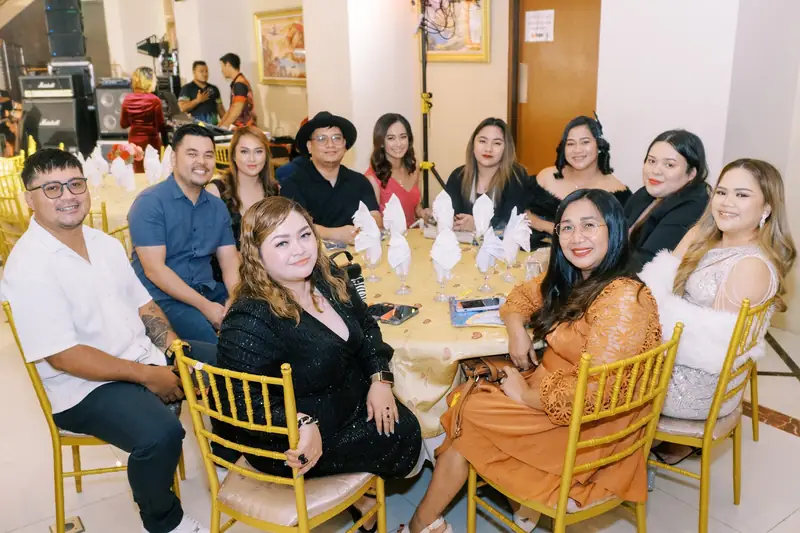 A table of ResolvedCX teammates smiling at a company dinner